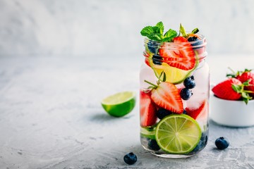 Infused detox water with blueberry, strawberry, lime and mint. Ice cold summer cocktail or lemonade.