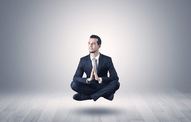 Businessman levitates and sitting in yoga position in an empty infinity space
