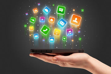 Businessman hand using phone with flying application icons around
