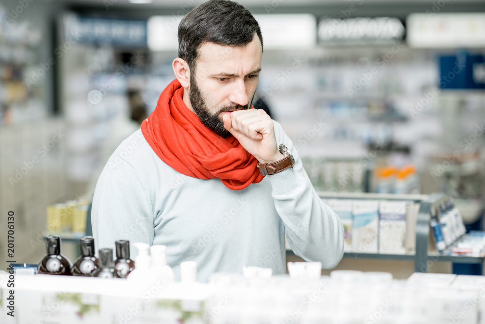 Wall mural man looking for medicaments in the pharmacy store