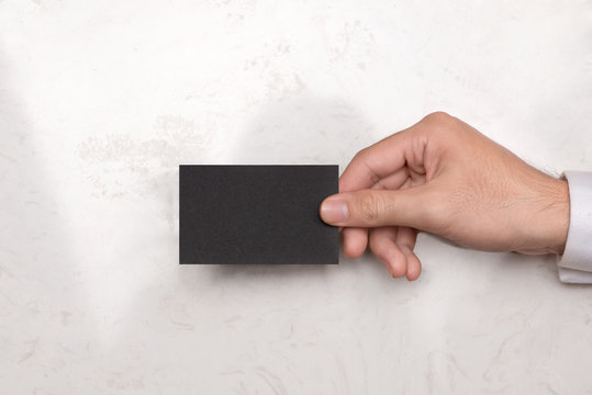 Mockup of black business cards in man's hand