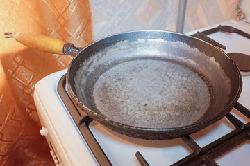 Старая чугунная сковородка на газовой плите в кухне