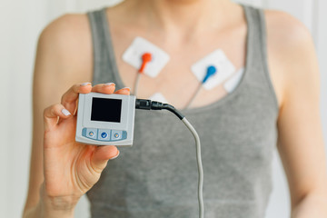 Woman wearing holter monitor device for daily monitoring of an electrocardiogram. Treatment of...