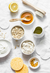 Natural moisturizing, nourishing, cleansing face mask - coconut oil, oatmeal, natural yogurt, vitamin E, honey, face brush, sponge on light background, top view. Flat lay, beauty products