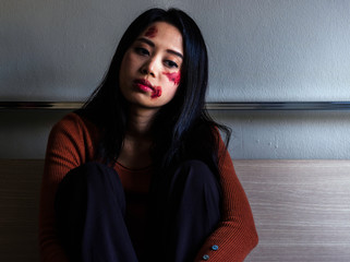 Sad girl sitting on the floor in corner of room.Unhappy depressed teenager