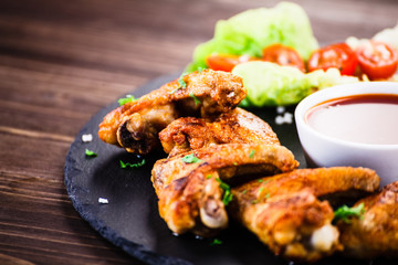 Grilled chicken wings, chips and vegetables