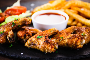 Grilled chicken wings, chips and vegetables