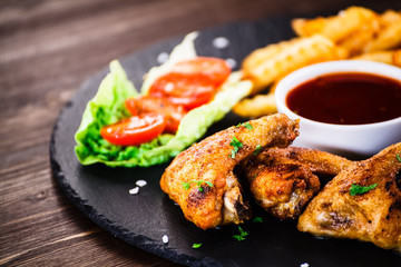 Grilled chicken wings, chips and vegetables