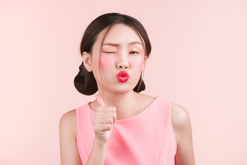 Beautiful asian girl with professional makeup and stylish hairstyle  isolated on pink. Cosmetics and make-up