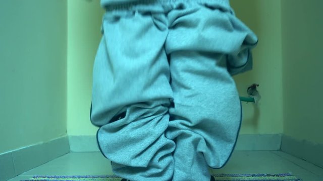 Man using toilet, taking off trousers