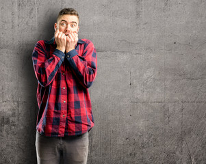 Young handsome man terrified and nervous expressing anxiety and panic gesture, overwhelmed