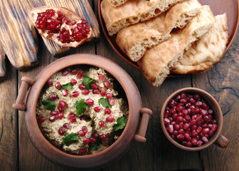 Satsivi with pomegranate seeds and cilantro is traditional georgian food. The Georgian dishes on a wooden background