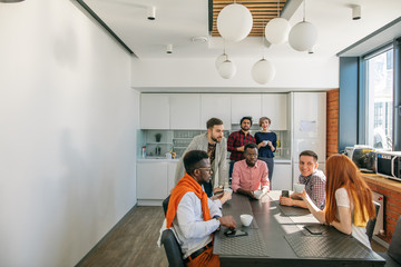 business team is gathered to drink coffe in modern kitchen room.