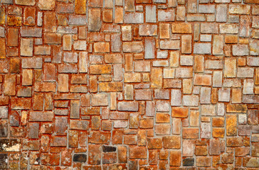 Old stone wall in orange and grey colors. Brickwork closeup photo for background. Rustic brick masonry.