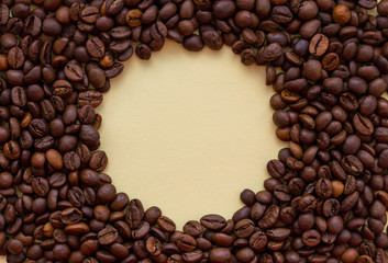 Roasted coffee beans with circle copy space in the middle. Aroma drink concept. Breakfast background. Coffee closeup with copy space. Cappuccino and espresso concept. 