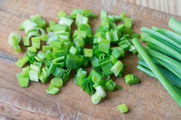 chopped green chives on wooden background