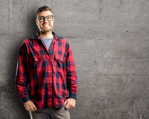 Young handsome man confident and happy with a big natural smile laughing, natural expression