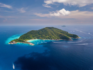 Aerial drone view of boats around the tree covered island of Ko Similan in Thailand