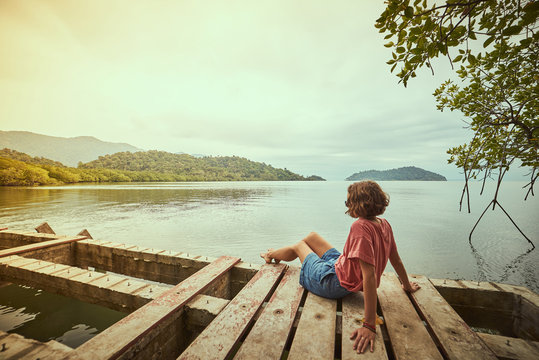 Traveling Girl On The Wood Pier. Pretty Young Woman And Tropical Landscape. Summer Lifestyle And Adventure Photo. Fish Eye Lens Image