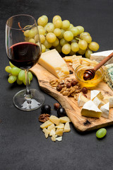 various types of cheese - brie, camembert, roquefort and cheddar and wine