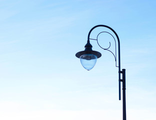 A street lantern in the form of a drop against the blue sky