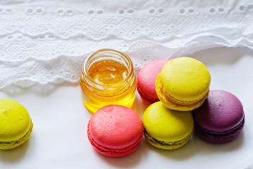 Colorful macaroons and jar of honey