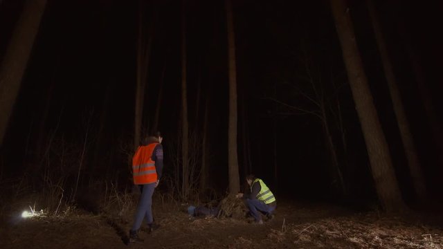 man and woman volunteers in a reflective waistcoat found a corpse in the forest