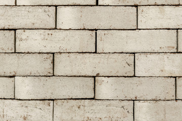 Wall of an old uneven brown brick. background