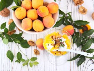 Healthy breakfast. Oat granola with yoghurt, apricot on a light wooden background