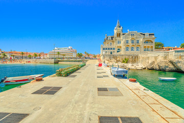 Seafront promenade with iconic Palace Seixas an old and abandoned building, and Praia da Ribeira beach or Praia dos Pescadores on seafront of Cascais, Lisbon Coast in Portugal from pier of Cascais. © bennymarty
