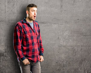 Obraz premium Young handsome man happy and surprised cheering expressing wow gesture