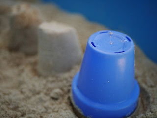 Children's sand pit with sand castles and blue bucket