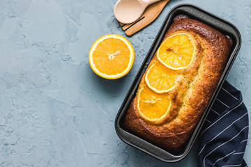 Healthy citrus pound cake on light blue concrete background. Top view, space for text. 