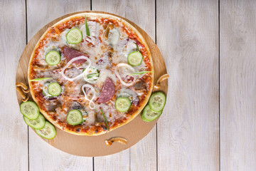 Vegetarian pizza served with fresh tomatoes, cucumbers on wooden background