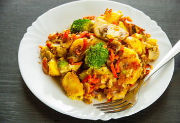 Mixed vegetables and mushrooms in a plate on dark wooden table