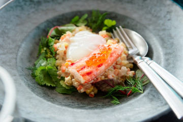 Russian salad with crab leg and poached egg