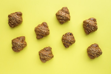 Croissant with almonds on yellow background