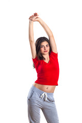 beautiful brunette teenager in red shirt and in sports pantsis is exercising, white background