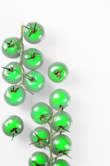 Glowing green cherry tomatoes on branch isolated on white background. Top view