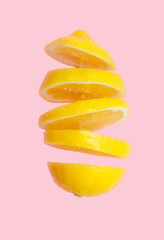 Flying lemon. Sliced lemon isolated on gradient pink background. Levity fruit