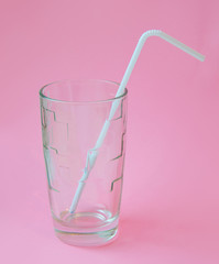 glass with a straw on a pink background. Fashion pastel summer design style concept
