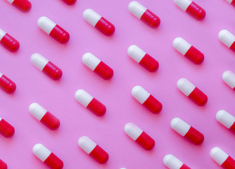 Capsule pills pattern on a pink background