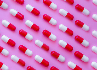 Capsule pills pattern on a pink background