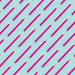 Pink pencils parallel on a blue background top view. Pastels fashion education concept.