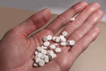 white pills in the male hand.