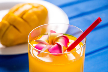 Mango smoothie in a glass glass and mango on a blue background. Mango shake.