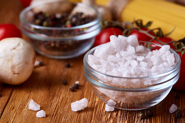 Uncooked pasta, tomatoes and spice on wooden background, top view, close-up, selective focus