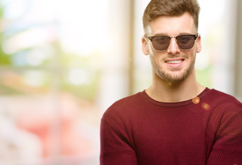 Handsome young man confident and happy with a big natural smile laughing