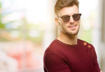 Handsome young man confident and happy with a big natural smile laughing