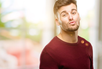 Fototapeta premium Handsome young man expressing love, blows kiss at camera, flirting